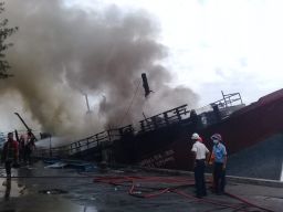Petugas berusaha memadamkan api yang membakar Kapal Lautan Inti Makmur. (Foto: Mahfud Hidayatullah/jatimnow.com)