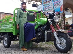 Devi Rosyida Ariyani berpose dengan motor gerobak sampah barunya. (Foto: Sahlul Fahmi/jatimnow.com)