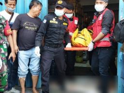 Petugas mengevakuasi korban dugaan perampokan disertai pembunuhan di Tandes, Surabaya. (Foto: Zain Ahmad/jatimnow.com)