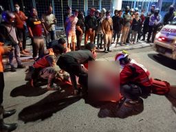 Petugas mengevakuasi wanita korban kecelakaan tunggal di Jl Mayjend Sungkono. (Foto: Unit Laka Satlantas Polrestabes Surabaya/jatimnow.com)