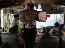Kanit Turjawali Sat Lantas Polres Lamongan saat mengedukasi warga dan pengemudi angkutan umum di Terminal Lamongan. (Foto: Fajar/jatimnow.com)