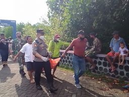 Petugas dan warga mengevakuasi mayat laki-laki tanpa celana. (Foto: Rony Subhan/jatimnow.com)