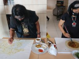 Amat Mulyono (kiri) saat melukis menggunakan cat bahan dapur di Midtown Residence Surabaya (Foto: Fajar Mujianto/jatimnow.com)
