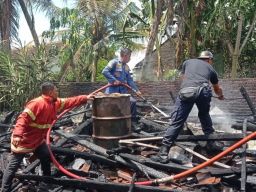 Petugas Damkar bersama warga memadamkan api yang melalap rumah Marsimin.(Foto: Dinas Pemadam Kebakaran Banyuwangi)