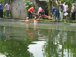 Polisi melakukan olah TKP dan mengevakuasi jenazah korban di kolam ikan.(Foto: Bramanta Pamungkas/jatimnow.com)