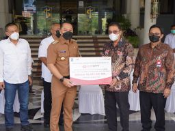 Direktur TI & Operasi bankjatim Tonny Prasetyo (kanan) menyerahkan CSR secara simbolis kepada Wali Kota Surabaya Eri Cahyadi. (Foto: Humas Bank jatim/jatimnow.com)