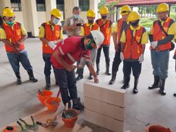 Instruktur di Balai Jasa Konstruksi Wilayah IV Surabaya memberikan contoh penggunaan Mortar Indonesia pada Jumat (8/4/2022) - (Foto-foto: SIG)