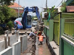 Pemasangan drainase di Jalan Desa Masangan Kulon.(Foto: Zainul Fajar)