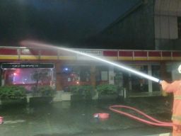 Petugas pemadam kebakaran saat berjibaku memadamkan api yang membakar minimarket. (Foto: Kedaruratan 112 Surabaya).