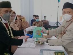 Salah satu pengantin melakukan wakaf Alquran (Foto: Ega for jatimnow.com)