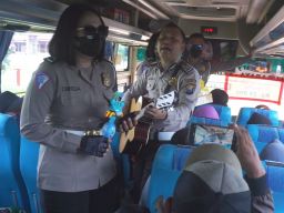 Sejumlah anggota polantas Polres Jombang saat menghibur para penumpang Bus Bagong, jurusan Surabaya ke Trenggalek.(Foto: Elok Aprianto)
