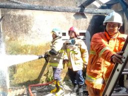 Petugas pemadam kebakaran sedang melakukan pembasahan di rumah yang terbakar (Foto: DPKP Kota Batu for jatimnow.com)