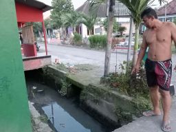 Warga Dusun Jabon, Desa Plosogeneng, Kecamatan/Kabupaten Jombang saat menunjukkan air saluran pertanian yang berbau (Foto: Elok Aprianto/jatimnow.com)