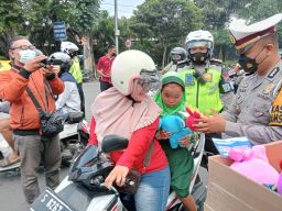 Penggunaan jalan saat mendapatkan boneka dari anggota Satlantas Polres Jombang.(Foto: Elok Aprianto)