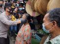 Momen di saat Kapolda Jatim Irjen Pol Nico Afinta memakaikan masker kepada pedagang Pasar Simo, Surabaya