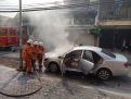 Petugas damkar memadamkan api yang membakar Toyota Camry 