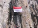 Bendera Merah Putih berukuran besar dikibarkan di tebing air terjun Kalipedati