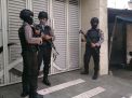 Sejumlah anggota polisi bersenjata lengkap mengamankan jalannya penggeledahan oleh Penyidik KPK di rumah kontraktor di Tulungagung