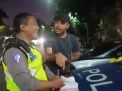 Aipda Abdul Malik Aziz, anggota Unit Lantas Polsek Genteng tetap tersenyum saat menghadapi pengemudi mobil yang tidak bersedia ditilang di Jalan Slamet atau sebelah Grand City Mall, Surabaya