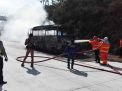 Petugas berusaha memadamkan api yang membakar bus pariwisata di Tol Madiun-Nganjuk