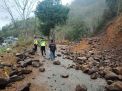 Jalan tertutup material batu dan tanah akibat longsor susulan 
