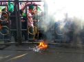 Massa aksi saat membakar kertas hingga pagar dewan nyaris terbakar, Jumat (14/9/2018).