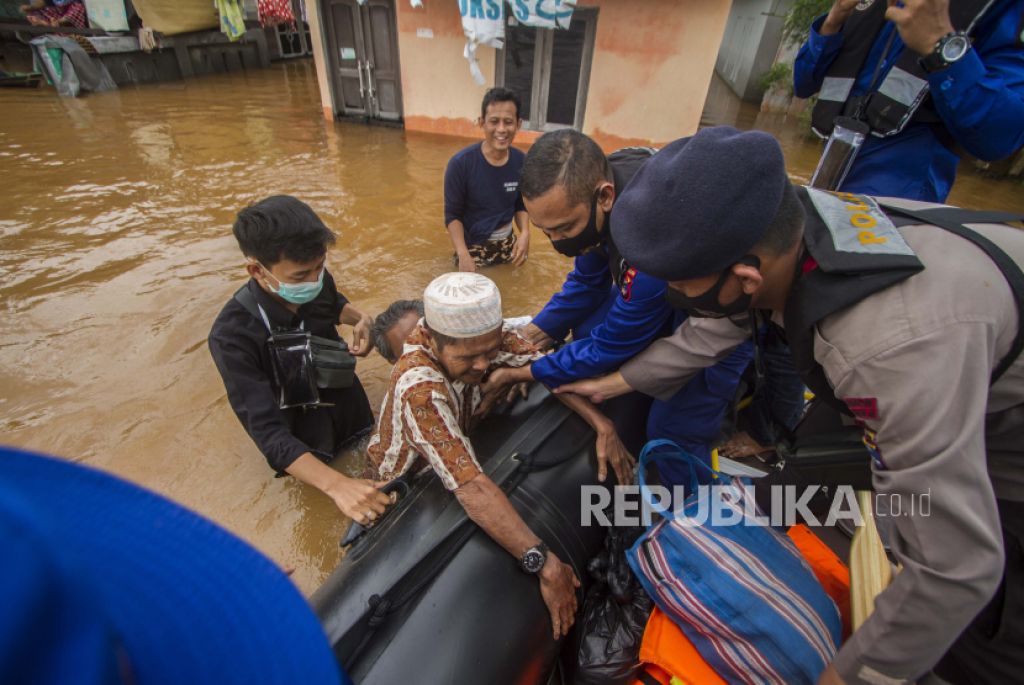 Tim penyelamat membantu seorang pria lanjut usia untuk naik ke perahu mereka di sebuah desa yang banjir di Banjar, Kalimantan Selatan (Foto: AP Photo/Putra via Republika) 