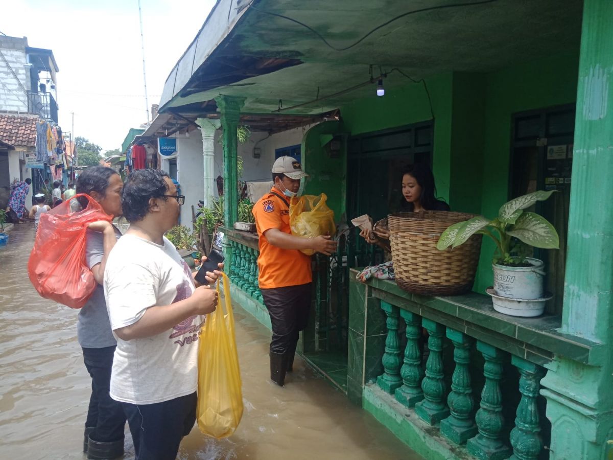 BPBD Kota Pasuruan membagikan konsumsi pada warga terdampak banjir.