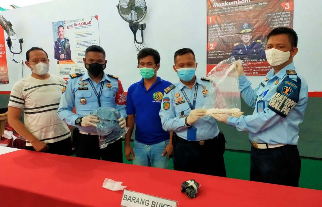 Petugas Lapas Banyuwangi menunjukkan narapidana berinisial SJP dan barang bukti 570 butir pil koplo