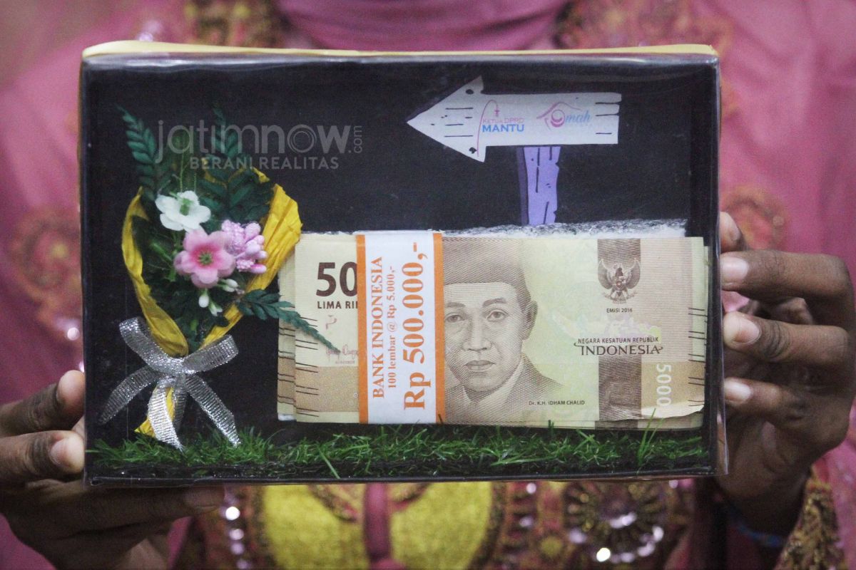 Pengantin menunjukkan mas kawin dalam prosesi pernikahan di gedung DPRD Gresik. (Foto: Sahlul Fahmi/jatimnow.com)