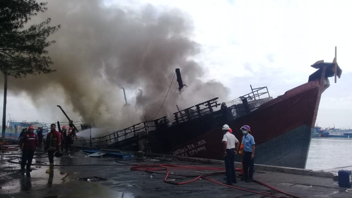 Petugas berusaha memadamkan api yang membakar Kapal Lautan Inti Makmur. (Foto: Mahfud Hidayatullah/jatimnow.com)