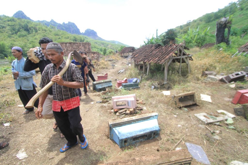 Warga Desa Ngadirojo, Kecamatan Sooko, Kabupaten Ponorogo melakukan pemindahan makam karena terancam tenggelam saat pengisian air di Waduk Bendo. (Foto: Mita Kusuma)