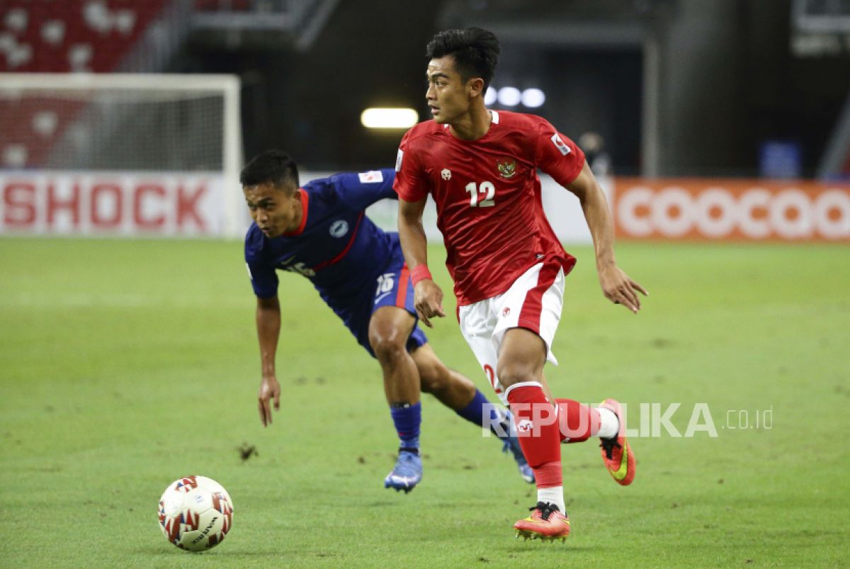 Pemain timnas Indonesia Pratama Arhan Alif Rifai (kanan) menguasai bola melewati Hami Syahin dari Singapura. (Foto: AP/Suhaimi Abdullah via Republika)