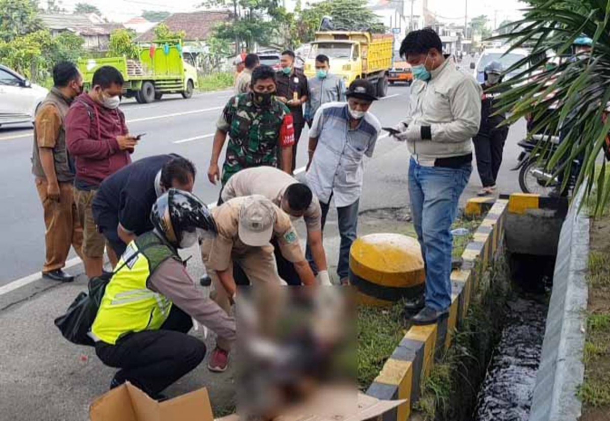 Mayat tanpa identitas tergeletak di pingir jalan depan perusahaan di Desa Kepulungan, Kecamatan Gempol, Kabupaten Pasuruan. (Foto: Moch. Rois/jatimnow.com)