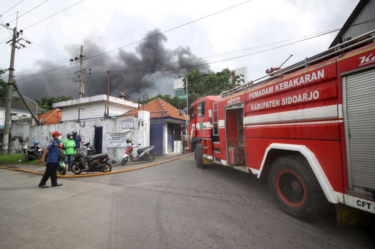 Petugas pemadam kebakaran berusaha memadamkan api yang membakar gudang PT Ode Cipta Semesta. (Foto: Achmad Supriyadi/jatimnow.com)