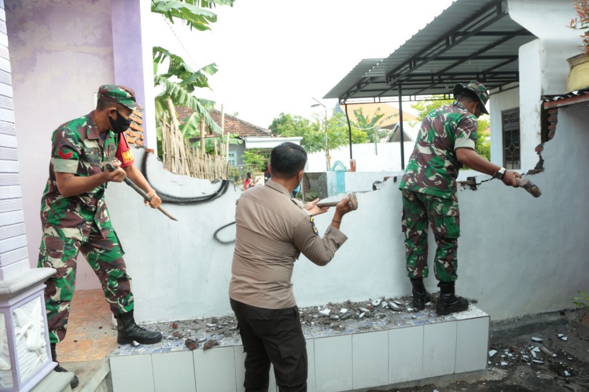 Polisi dan TNI membongkar tembok yang menutup akses warga di Mangunharjo. (Foto: Mahfud Hidayatullah/jatimnow.com)
