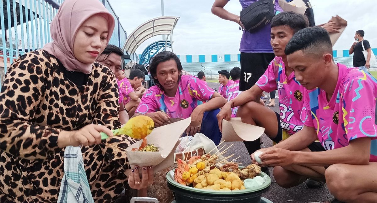 Narti pedagang nasi boran saat melayani para pemain sepak bola di Stadion Surajaya Lamongan (Foto: Sahlul Fahmi/jatimnow.com)