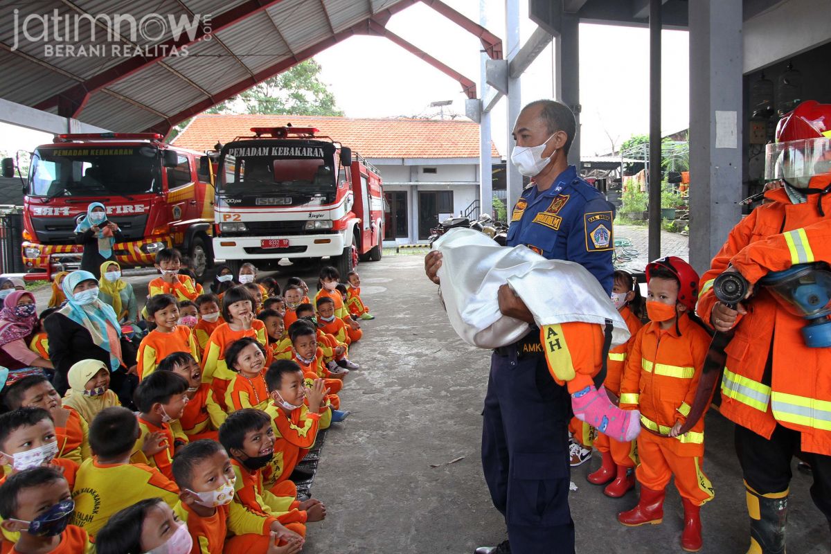 Petugas Damkar Gresik memperagakan cara mengevakuasi korban kebakaran.