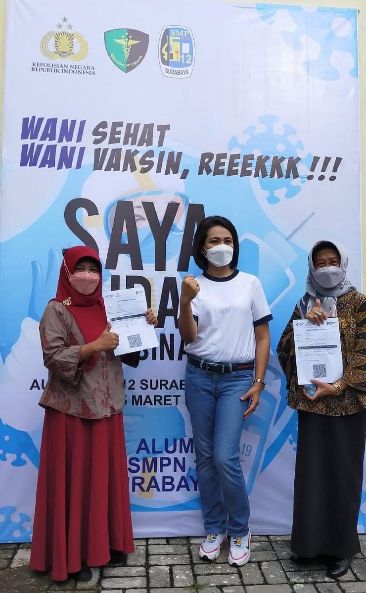 Dini Herawati selaku koordinator acara Vaksin Massal SMPN 12 Surabaya bersama Kasek dan Wakasek SMPN12 Surabaya setelah menerima sertifikat vaksin booster.