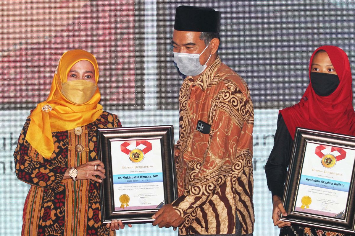 Anggota Komisi III DPRD Gresik Hamzah Takim saat memberikan penghragaan kepada dr. Mukhibatul Khusna, Kepala Dinas Kesehatan Kabupaten Gresik (kiri).