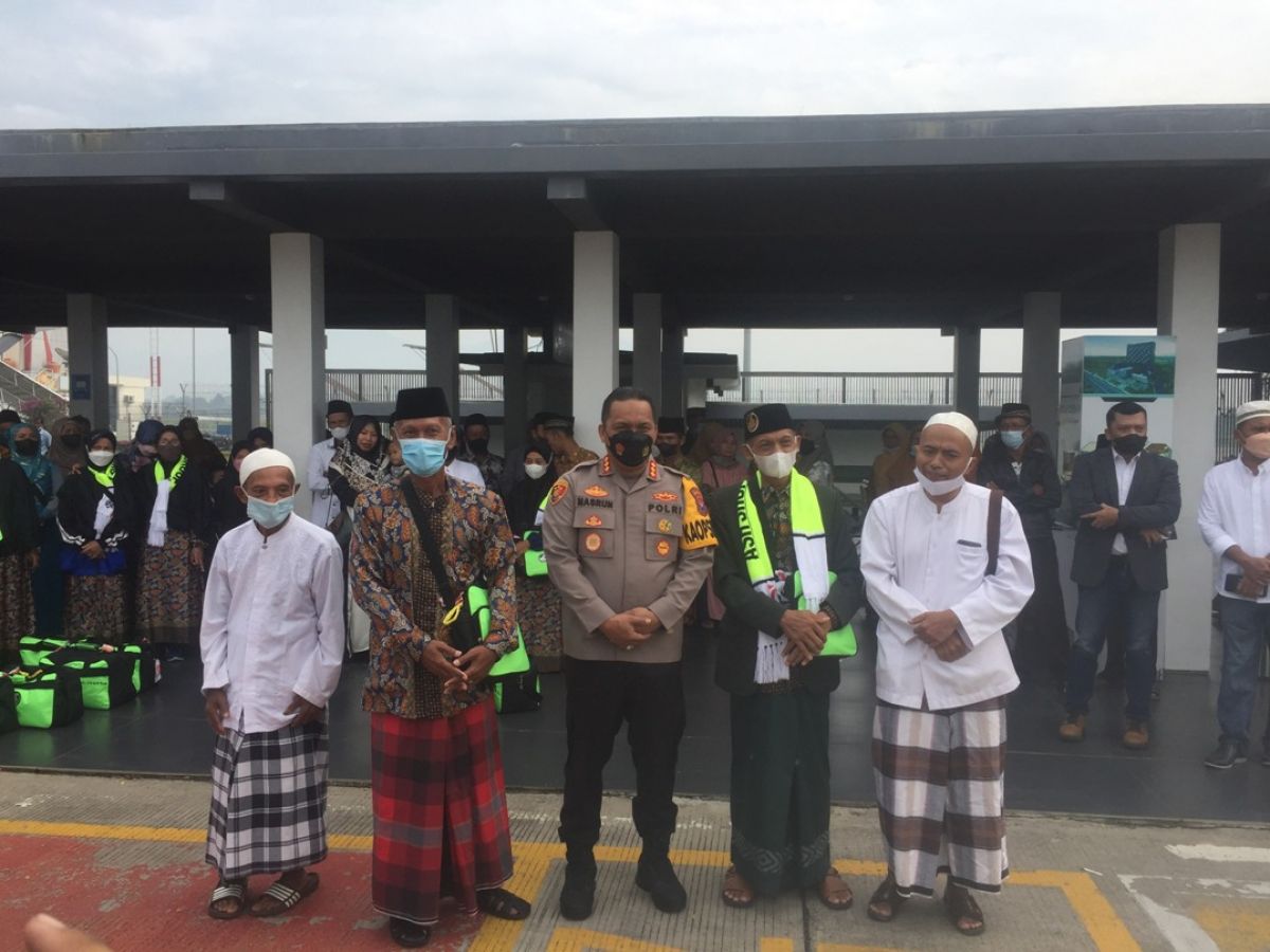 Kapolresta Banyuwangi Kombes Pol Nasrun Pasaribu saat mengantar Imam Muslih bersama istrinya di Bandara Banyuwangi.(Foto: Rony Subhan/jatimnow.com)