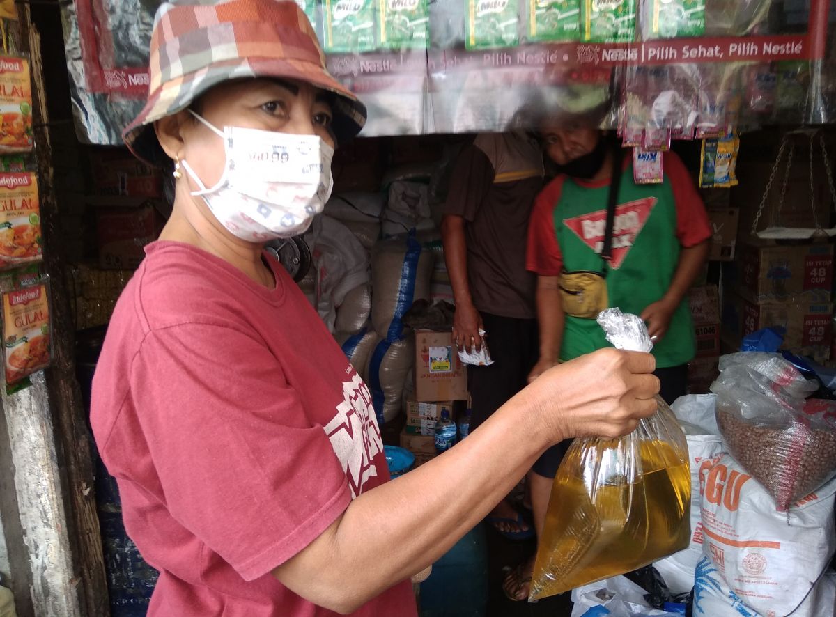 Pembeli minyak goreng curah di pasar tradisional Jombang. (Foto: Elok Aprianto/jatimnow.com)