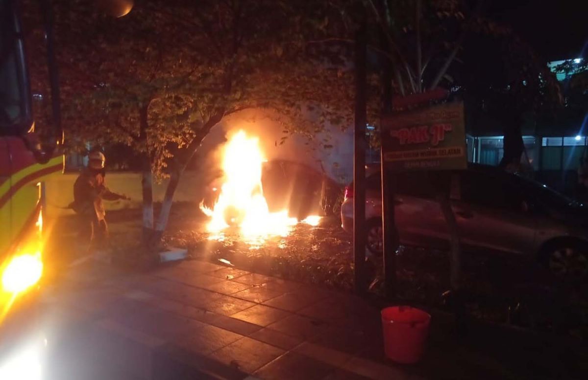 Petugas berusaha memadamkan api yang membakar mobil Mercy (Foto-foto: Info Kedaruratan 112 Surabaya)