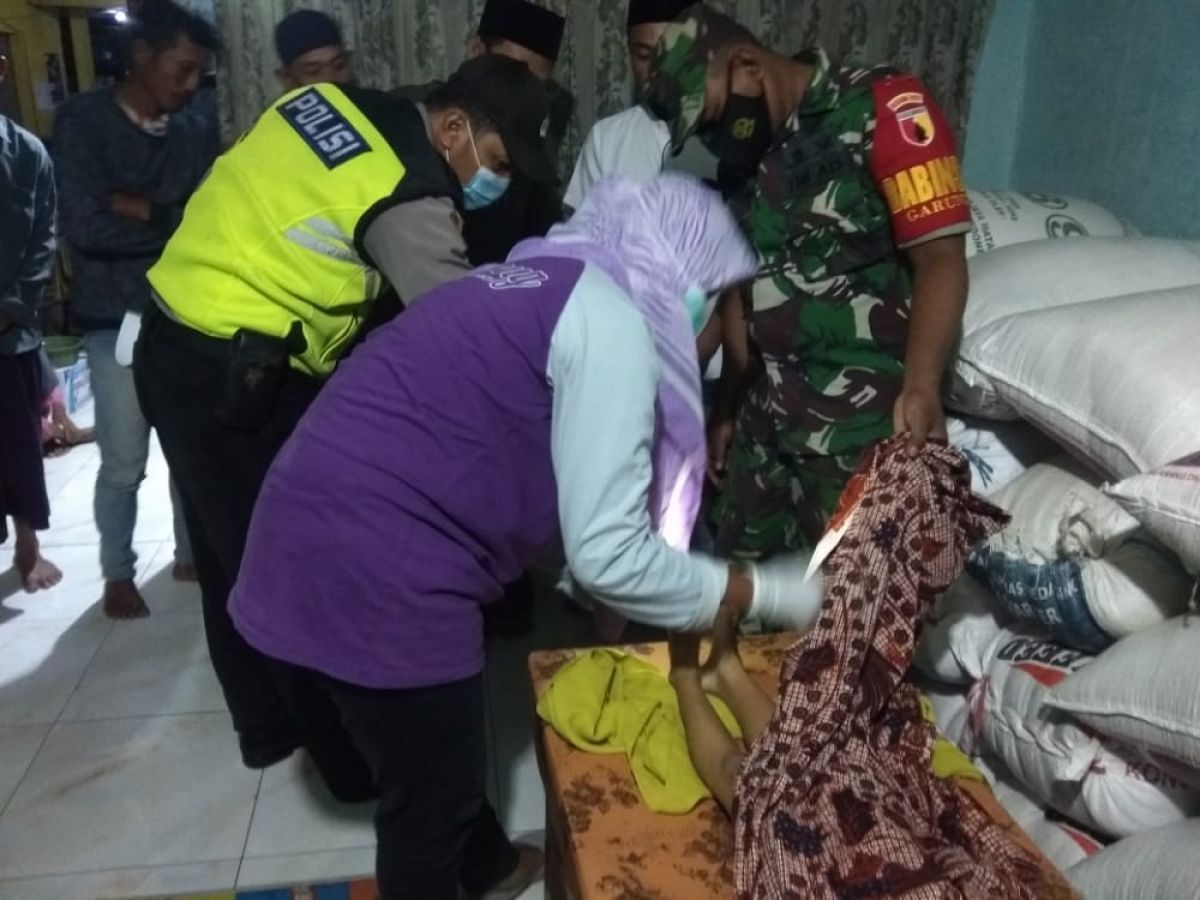 Petugas kesehatan saat memeriksa mayat seorang anak yang tenggelam di Sambeng Lamongan. (Foto: Humas Polres Lamongan for jatimnow.com)