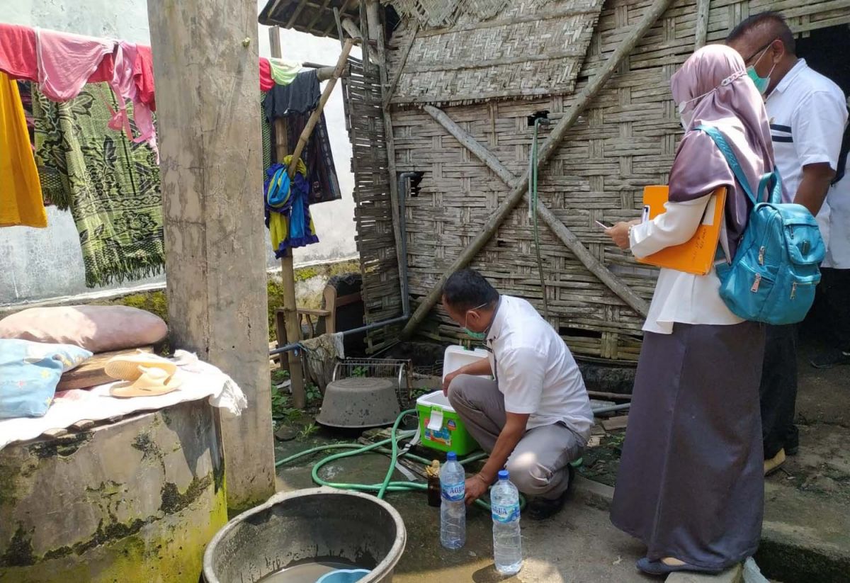 Petugas dari Dinas Kesehatan Jombang saat mengambil sampel air dari sumur yang ada di rumah korban (Foto: Elok Aprianto/jatimnow.com)