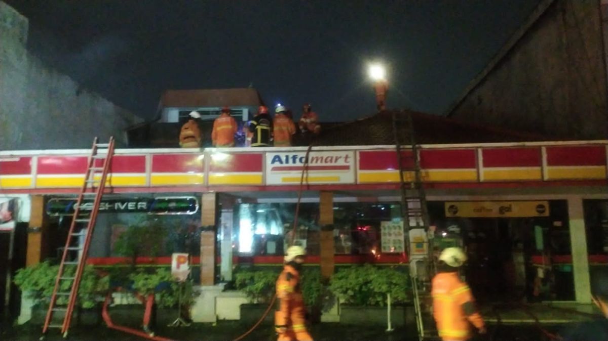 Petugas pemadam kebakaran saat berjibaku memadamkan api yang membakar minimarket. (Foto: Kedaruratan 112 Surabaya).