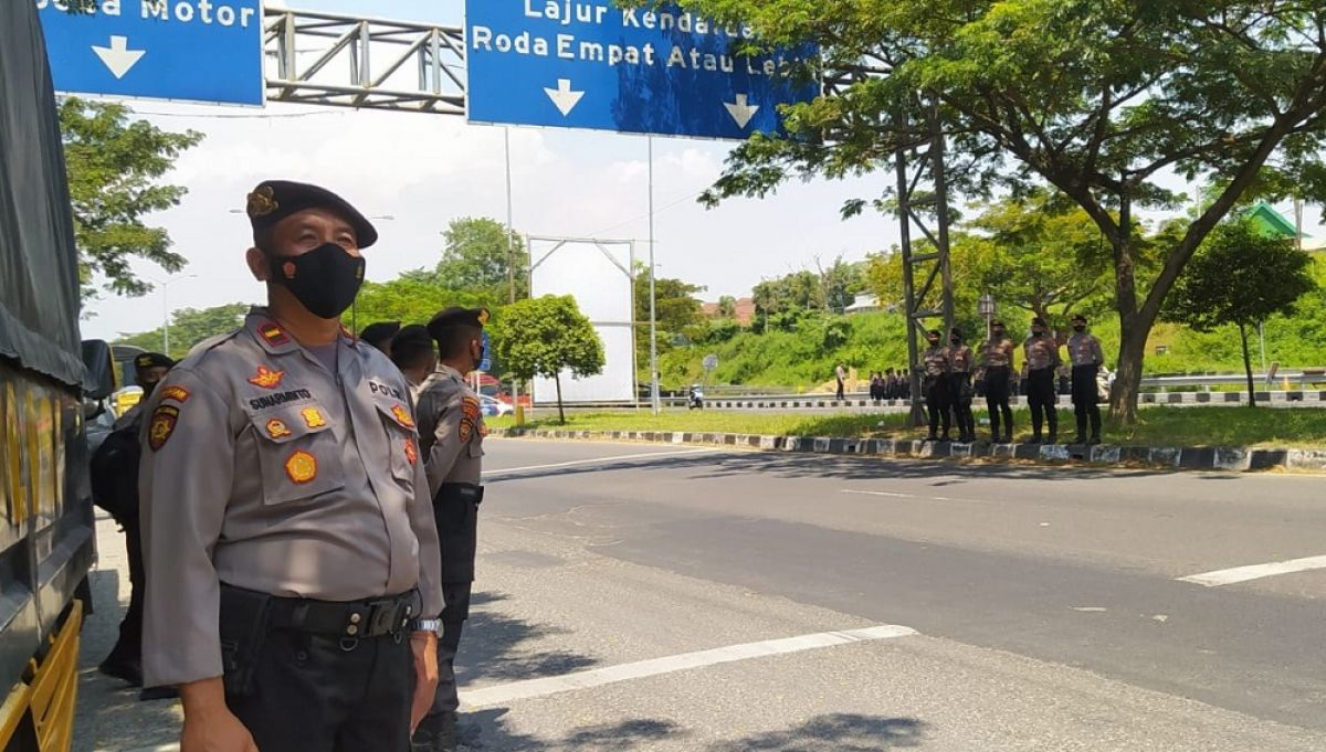 Personel kepolisian siaga menunggu kedatangannya ratusan massa yang berencana blokade akses Suramadu. (Foto: Fathor Rahman/jatimnow.com)