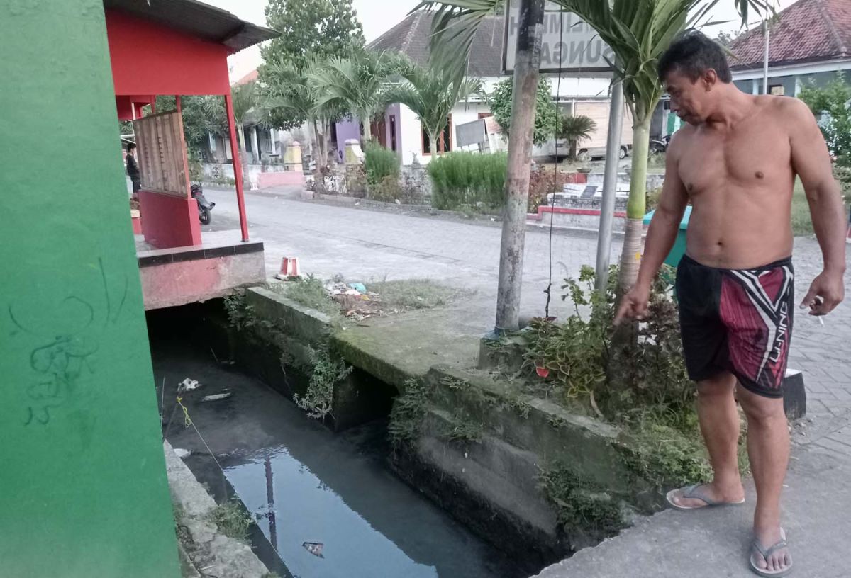 Warga Dusun Jabon, Desa Plosogeneng, Kecamatan/Kabupaten Jombang saat menunjukkan air saluran pertanian yang berbau (Foto: Elok Aprianto/jatimnow.com)