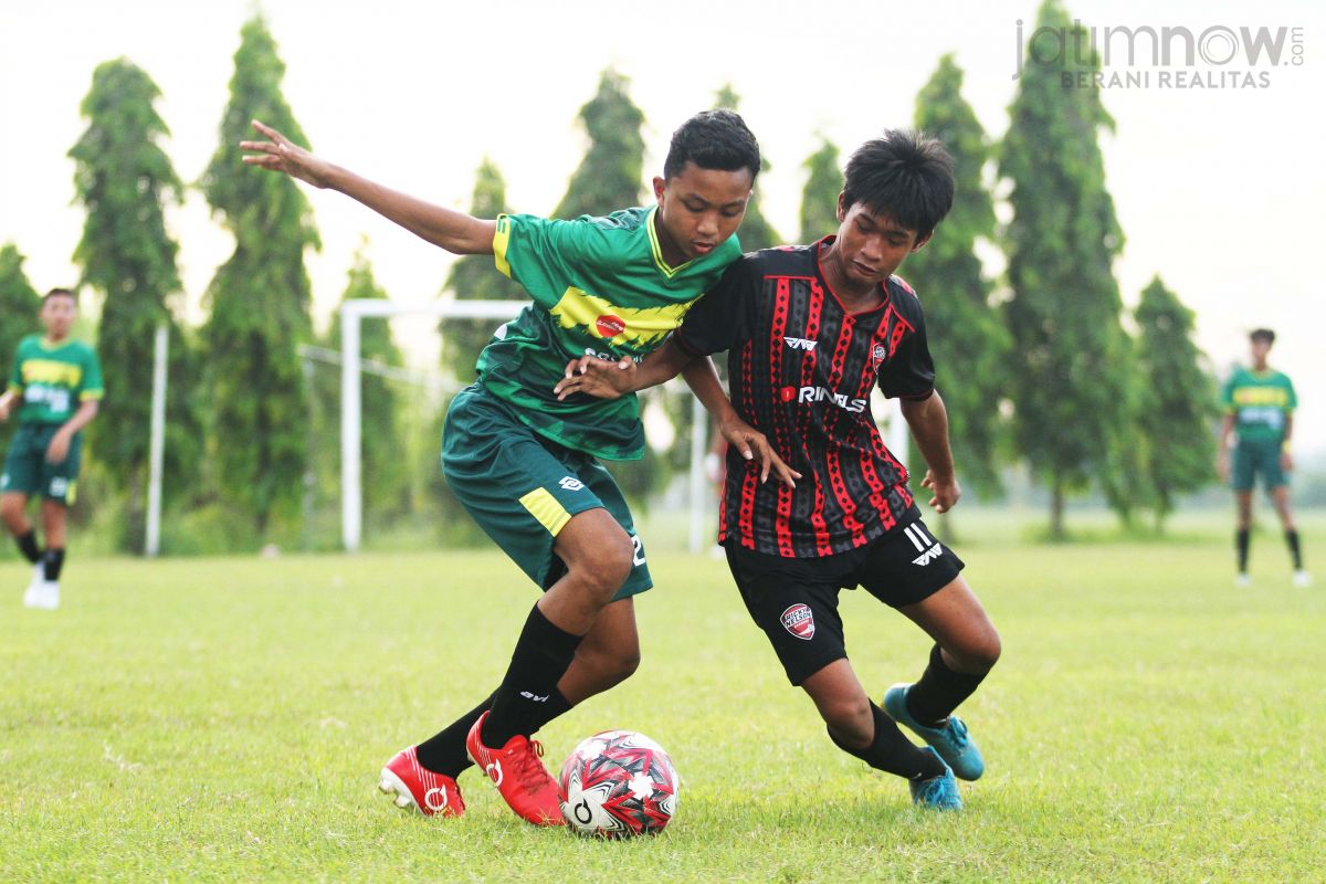 Pemain Gresik Baru U-15 (hijau) berduel dengan pemain Ricky Nelson Academy (Foto: Sahlul Fahmi/jatimnow.com)