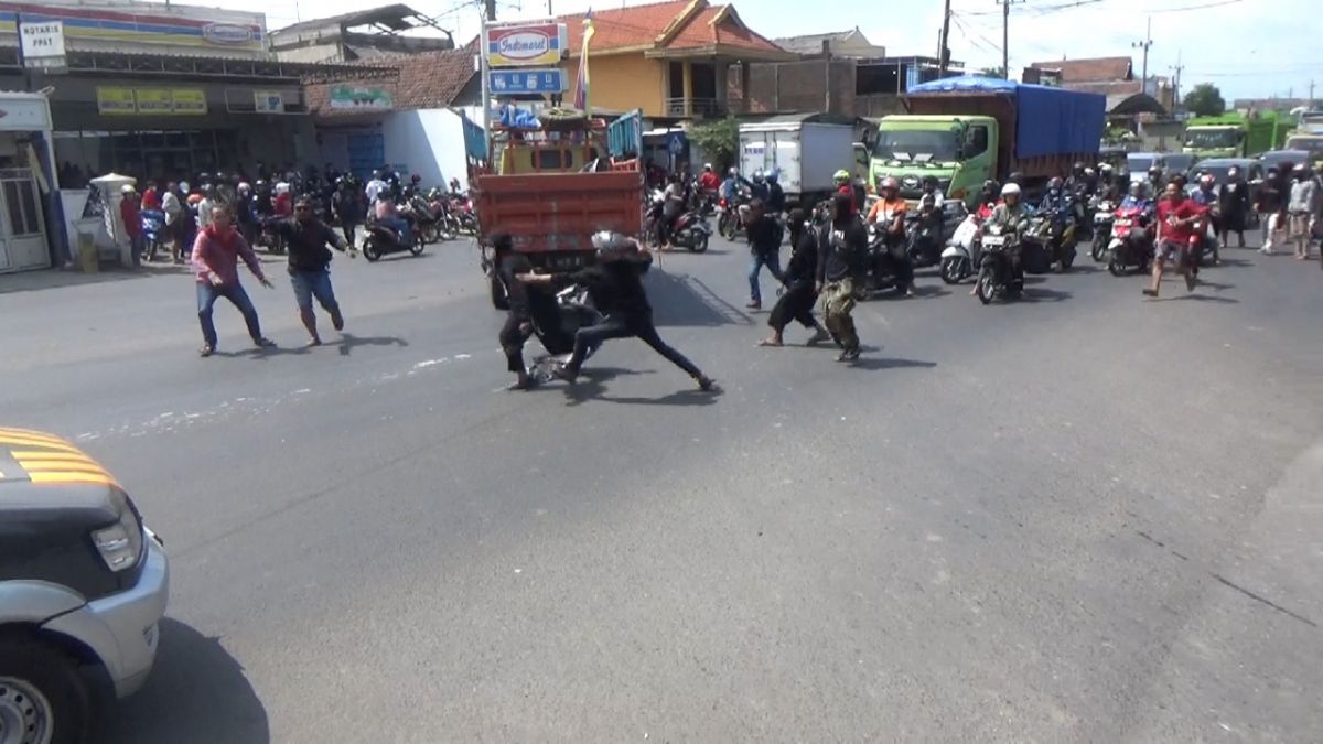 Anggota konvoi perguruan silat saat melakukan penyerangan pada pengguna jalan yang melintas di Jalan Raya Mojoagung. (Foto: Elok Aprianto/jatimnow.com)
